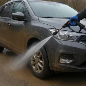 Auto wordt afgespoten met hogedrukreiniger om modder te verwijderen.